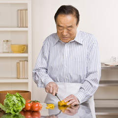 Fototapeta na wymiar Man preparing wholesome salad in kitchen for dinner