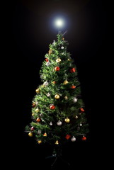 Decorated Christmas-tree on black background .