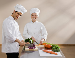 Chefs whites preparing and chopping fresh vegetables