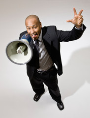 Angry businessman shouting instructions into megaphone