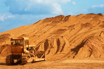 Little yellow bulldozer at worksite.