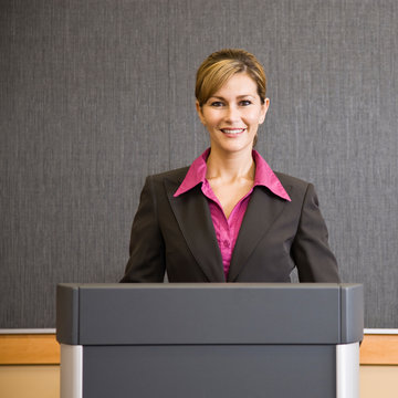 Businesswoman Standing Behind Podium