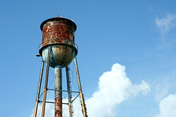 A Old rusty watertower against blue sky