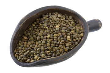 French green lentils on a primitive, wooden scoop, isolated