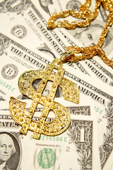 Golden dollar-symbol necklace on cash