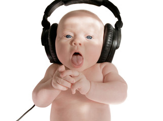 baby girl sings in big black headphones, on white