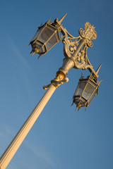 Fototapeta na wymiar Close up of classical metal lamp post under warm light