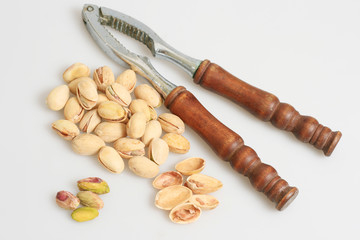 pistachio nuts with nut cracker isolated in white background.