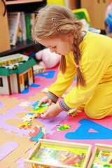 Cute child playing with puzzle
