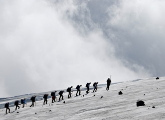 group of people climbing snowy mountain - 9756508