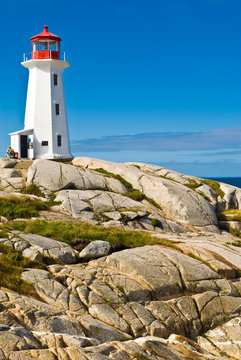 Heritage lighthouse on a rocky beach. Peggy's Cove, Canada.