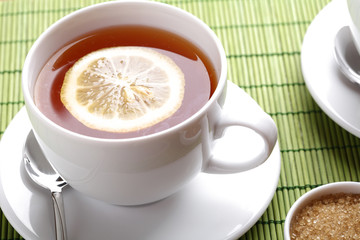 Hot teacup with lemon and sugar.