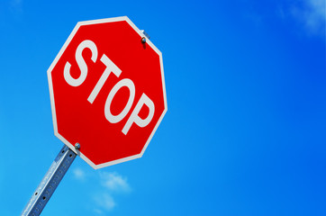 Stop sign against blue sky