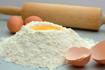 Flour and eggs on a kitchen table for preparation a dough