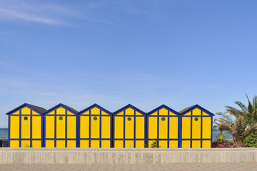 Naklejka premium Blue and yellow wooden cabins at the beach