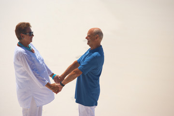 holding hands on sandy beach