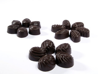 Seventeen chocolates in three groups isolated on white