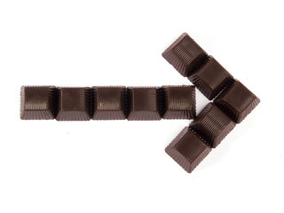 Chocolates composed in arrow on a white background