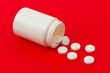 Bottle of pills on redl background