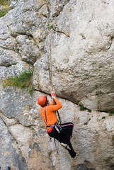 The climber rises upwards on a rock