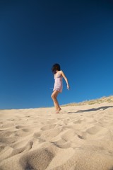 dressed woman walking on the sand