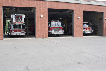Three garage bays of fire house open with firetrucks - 9783372