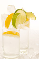 SSparkling water with slices of fresh lemon and lime on  white.
