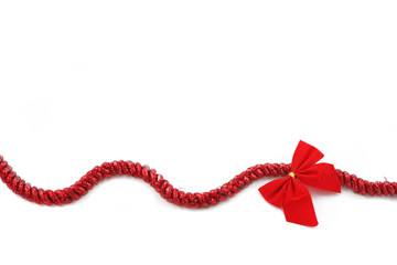 red christmas tinsel and bow on a white background