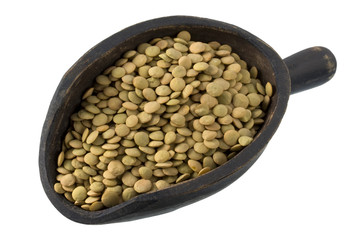 green lentils on a primitive, wooden scoop, isolated