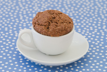 Chocolate cupcake on a blue polka dot background