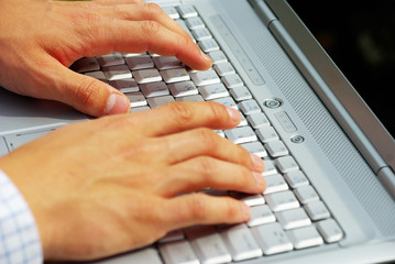 male hands typing on a laptop