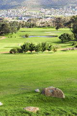 Obraz premium A picturesque golf course nestled between mountains.