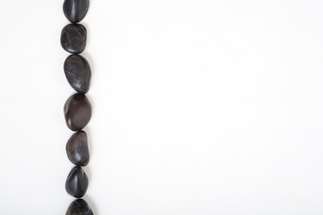 Obraz premium Black stones in line on white background