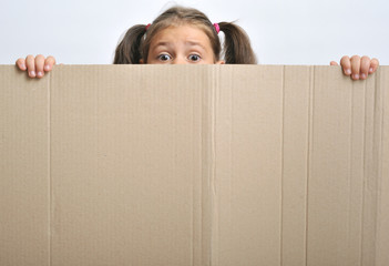 Little girl behind a blank cadboard