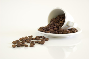 White coffee cup and coffee beans on a light background