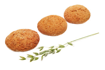 Three oatcakes and green panicle of oat on white background.