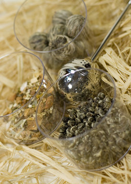 silver tea-strainer and tree kinds of tea on strow