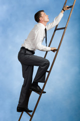 Photo of young businessman climbing upwards