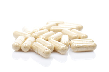Capsules reflected on white background with shallow DOF