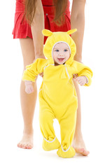 baby in yellow suit making first steps