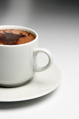 Cup of hot coffee over grey background