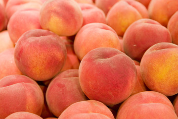 A stack of fresh ripe peaches in a market