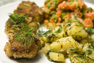 Pork burgers with potatoes, carrot and green peas