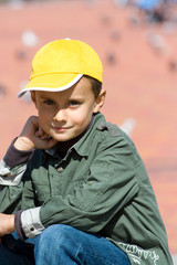 Cute boy with cap against blurred red background