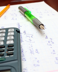pen, calculator and math calculation after home work