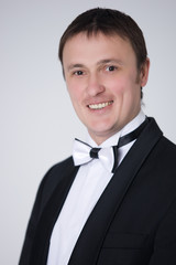 handsome man in suit with bow-tie is smiling