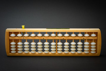An abacus, a traditional calculating device on black background