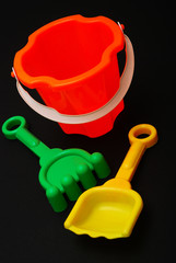 Plastic beach toys on black background