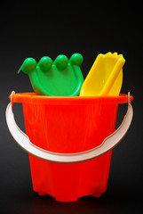 Plastic beach toys on black background