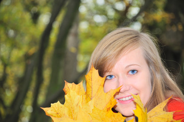 nice girl with yellow maple's leaves